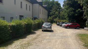 Een grindpad dat leidt naar een gebouw met meerdere ramen en een schotelantenne.