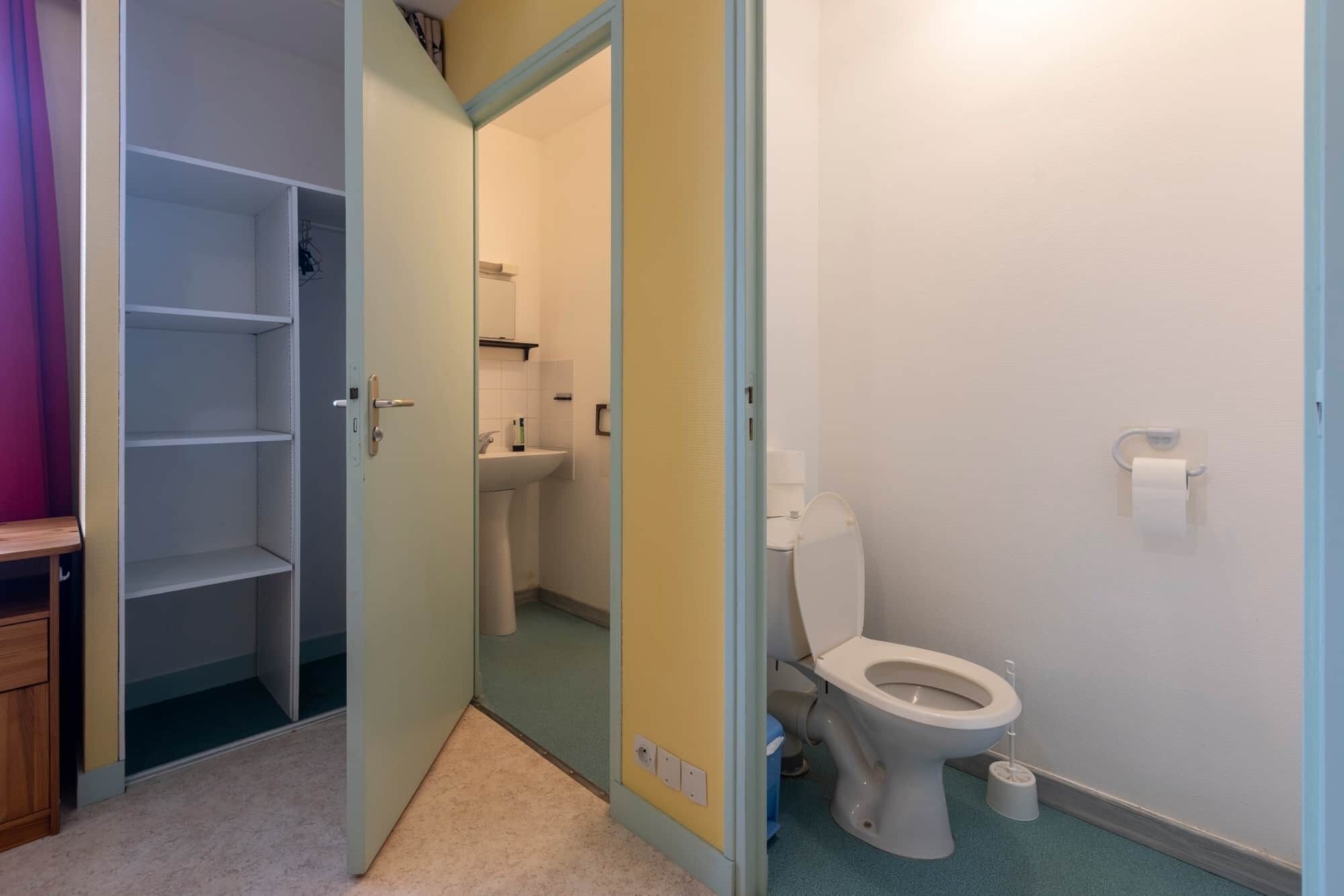 A bathroom with a toilet, a sink, and a shower area.