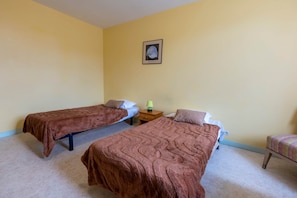 A room with two single beds, a small bedside table with a lamp, and a framed picture on the wall. - Room 104 - Le Bas Mont Residence (Moulay)