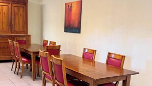 A dining area with a wooden table and chairs, a cabinet, and a painting on the wall. - Room 104 - Le Bas Mont Residence (Moulay)