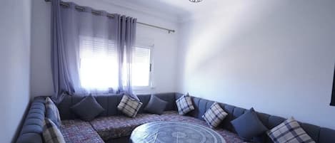 A modern living room with a sectional sofa, patterned rug, and a round coffee table.