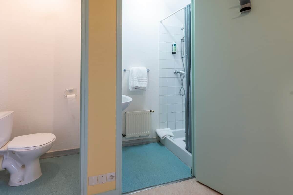 A bathroom with a toilet, sink, and shower area.