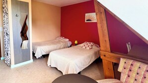 A bedroom with two beds, a wooden staircase, and a red wall. - Room 202 - Le Bas Mont Residence (Moulay)