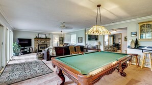 A billiards room with a pool table, a fireplace, and a television. - Game Room, Deck + Yard! Cadillac Family Escape (Cadillac)