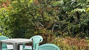 A table and two chairs in an outdoor setting with greenery in the background. - Room 105 - Le Bas Mont Residence (Moulay)