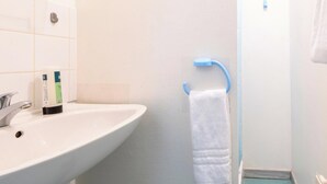 A bathroom with a white sink, a blue towel rack, and a white towel hanging on it. - Room 105 - Le Bas Mont Residence (Moulay)