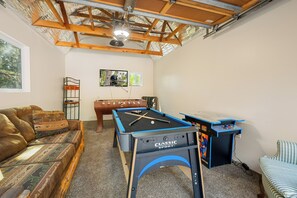 A room with a pool table, a sofa, a futsal table, and a ceiling fan. - All Seasons Lodge: Family Haven in Big Bear (Big Bear Lake)