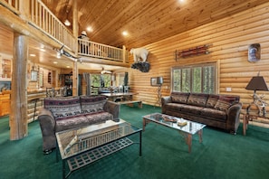 A log cabin interior with a living room, a dining area, and a balcony. - All Seasons Lodge: Family Haven in Big Bear (Big Bear Lake)