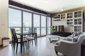 Ein modernes Wohnzimmer mit Balkon, Essbereich und einem Fernseher-Schrank.