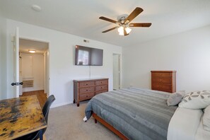 A bedroom with a bed, a television, a ceiling fan, and a dresser. - Walk to Med Center! Extended Wilmington Condo (Wilmington)