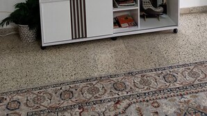 Eine weiße Unterhaltungseinrichtung mit einem flachbildfernseher darüber, einer kleinen Pflanze und einem gerahmten Zitat an der Wand.