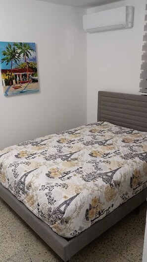 A bedroom with a bed, a painting, and an air conditioning unit. - San Antonio Puerto Rico (Aguas Buenas city)