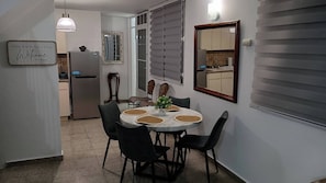 Eine kleine Küche mit Essbereich, einem Kühlschrank, einem Spiegel und einem Willkommensschild.