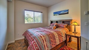 A bedroom with a bed, a window, a nightstand, a lamp, and a painting on the wall. - Steps to Fritz Creek! 2-Unit Family Retreat (Fritz Creek)