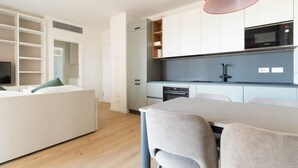 Uma cozinha moderna com eletrodomésticos embutidos, um espaço de jantar com mesa e cadeiras, e um closet amplo com prateleiras.