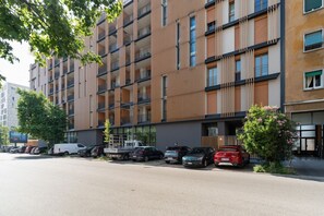 Ein mehrstöckiges Gebäude mit Parkplatz davor.