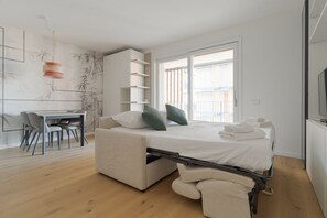 Ein modernes Schlafzimmer mit einem Schlafsessel, einem Schreibtisch und einem Essbereich.