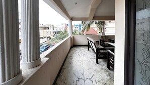 Ein Balkon mit Marmorboden, einer Holzbank und Blick auf die Stadtlandschaft.