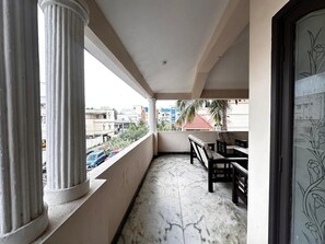 A balcony with a marble floor, a wooden bench, and a view of the cityscape. - Spacious 5-bedroom bungalow in gorgeous Chennai with AC (Chennai)