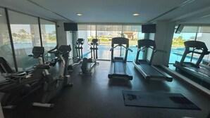 Ett gym med konditionsmaskiner, ett löpband och en roddmaskin.