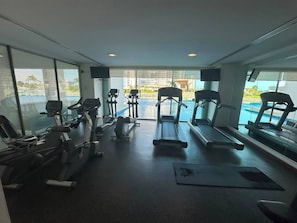 Ein Fitnessraum mit Cardiogeräten, Laufbändern und Rudergeräten.