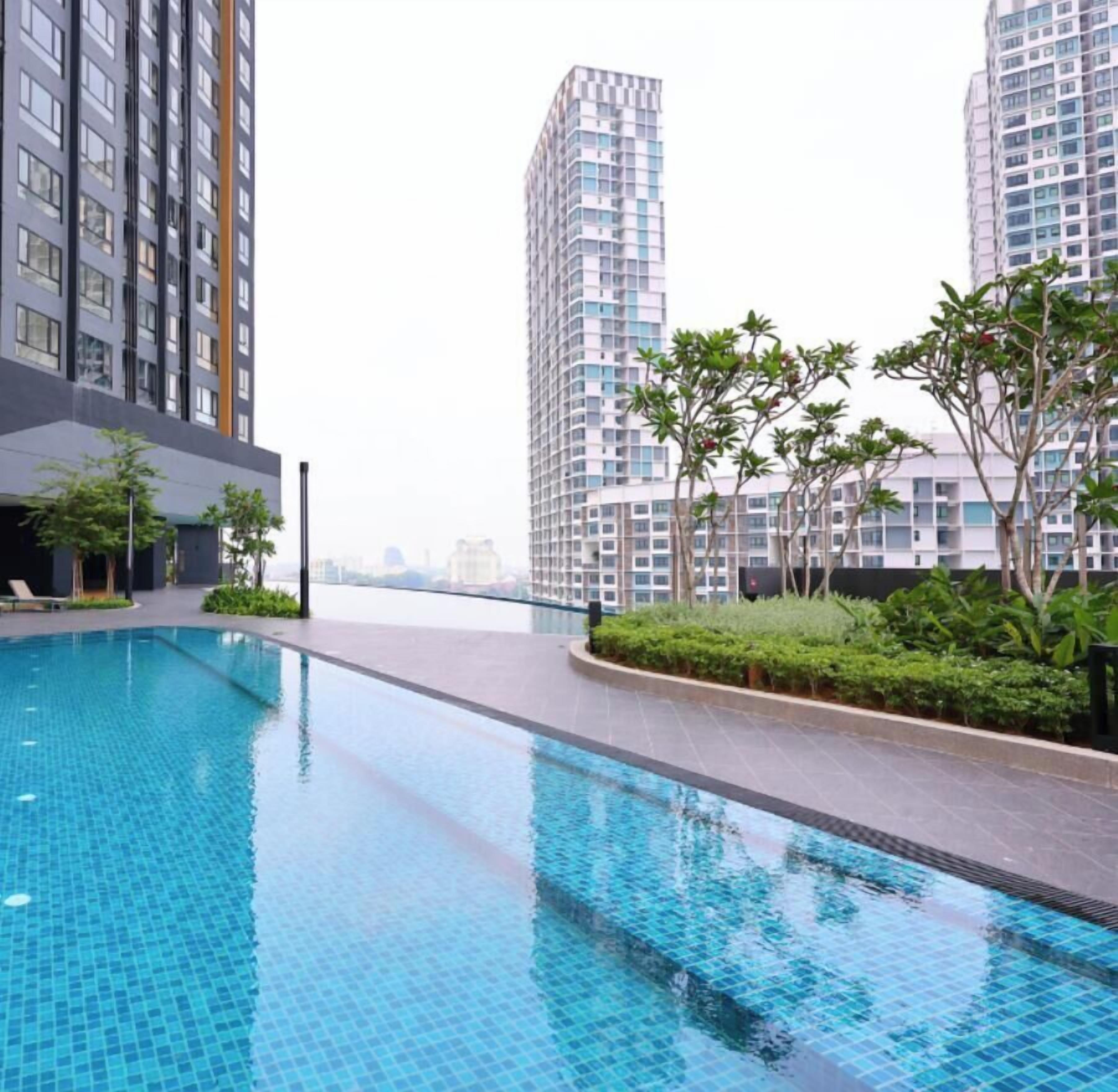 A swimming pool area with high-rise buildings in the background.