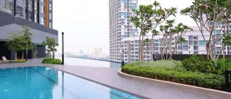 A swimming pool area with high-rise buildings in the background.