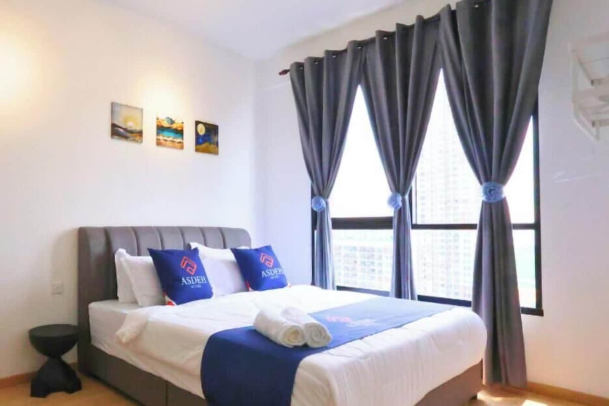 Ein Hotelzimmer mit einem Bett, einem Nachttisch und einem Fenster mit Vorhängen.