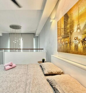Ein modernes Hotelzimmer mit einem großen Bett, einem Bild des Eiffelturms und einer kleinen Pflanze auf dem Nachttisch.