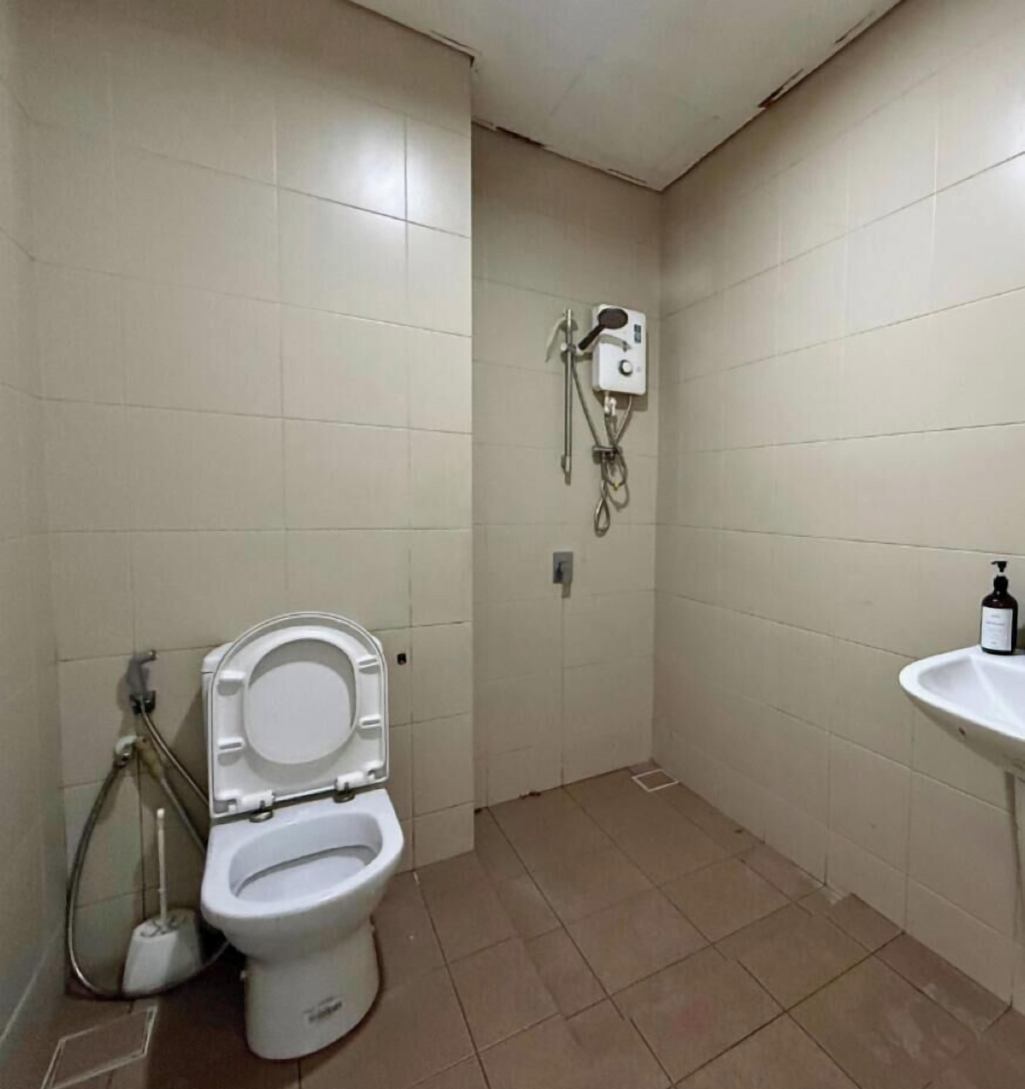 Ein kleines Badezimmer mit Toilette, einem Händetrockner und einem Waschbecken.