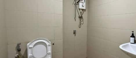 A small bathroom with a toilet, a hand dryer, and a sink.