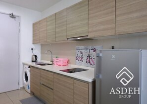 A modern kitchen with wooden cabinets, a built-in washing machine, a sink, and a refrigerator. - I-City Shah Alam Residences By Asdeh (Shah Alam)