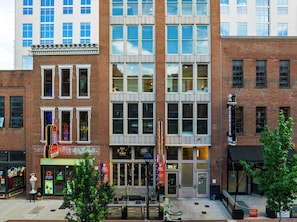 A multi-story building with a brick facade, large windows, and a storefront with illuminated signage. - Stylish Downtown Nashville Condo • Near Broadway + Printer's Alley | Headliner (Nashville)