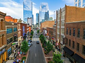 A city street lined with historic buildings and modern skyscrapers. - Historic Saddlery Condo • 2 Mins to Broadway + Near Printer's Alley | Key Note (Nashville)