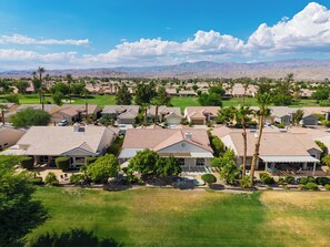 A residential area with houses, a golf course, and mountains in the background. - Golf Views + BBQ Patio | Mins to Indian Wells | Palm & Par (Palm Desert)