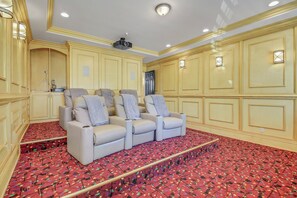 Ein Zimmer mit einem roten Teppich, einem weißen Sofa mit grauen Kissen und cremefarbenen Wänden mit dekorativer Verzierleiste.