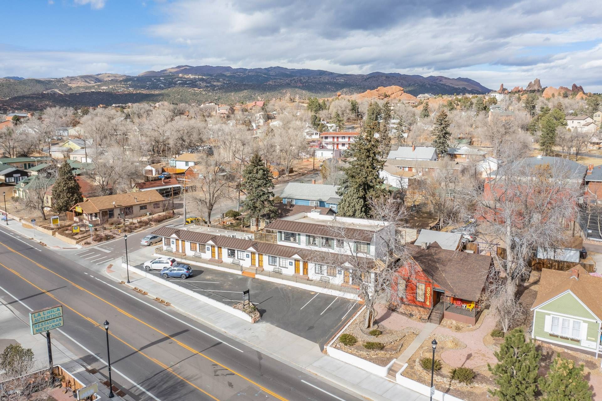 Un pueblo con una calle principal, edificios y montañas al fondo.
