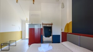 Ein Hotelzimmer mit Bett, Schrank und Spiegel.