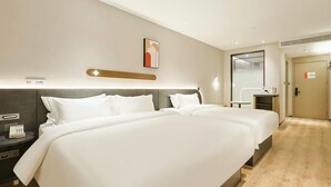 Una habitació d'hotel amb un llit gran, taules de nit, un escriptori i una cadira.