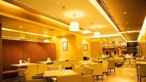 Un restaurant amb diverses taules i caires, una zona de mostrador i una secció de seients amb un banc amb seients.