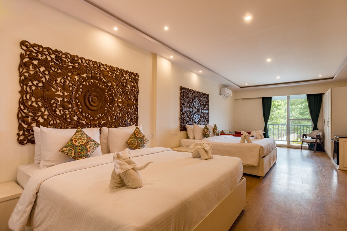 Habitación de hotel con dos camas, paneles decorativos en la pared y vistas al exterior.