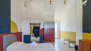 Ett hotellrum med två sängar, en garderob, en spegel och ett nattduksbord.
