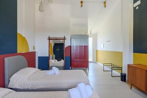 Ein Hotelzimmer mit zwei Betten, einem Schrank, einem Spiegel und einem Nachttisch.