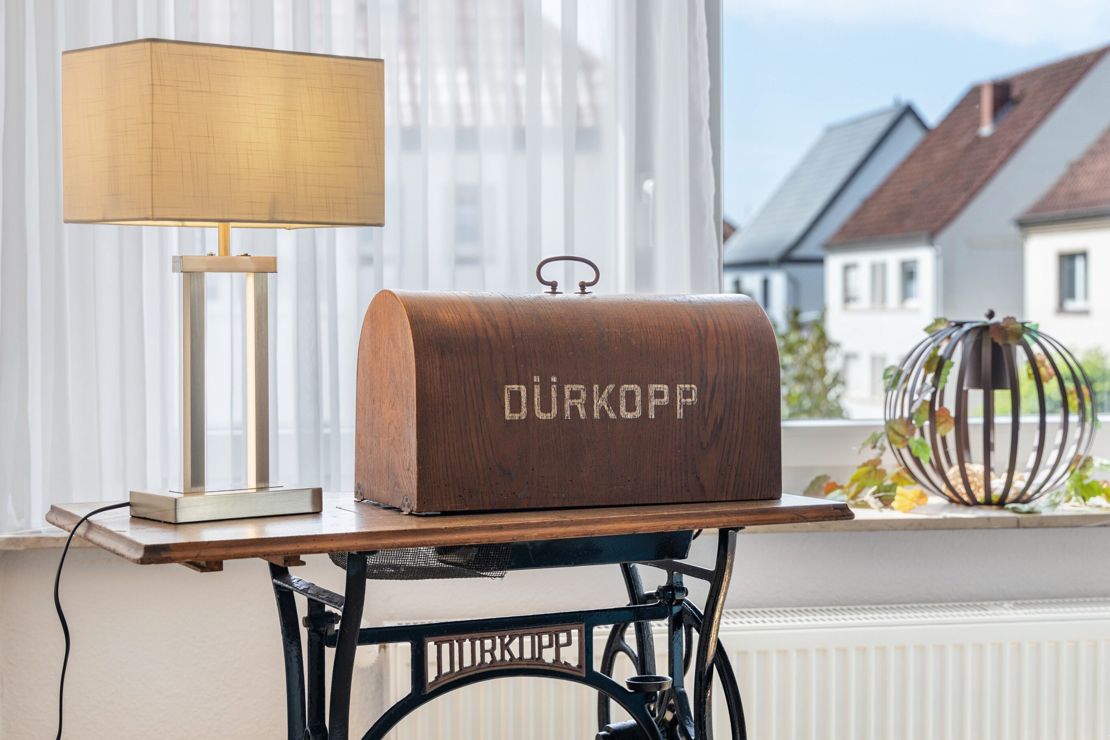 En trälåda med inskriften ”DURKOPP”, placerad på ett bord med en lampa bredvid.