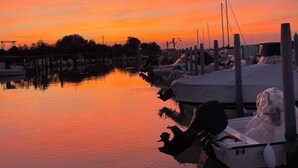 Un puerto deportivo con barcos amarrados a muelles de madera al atardecer.