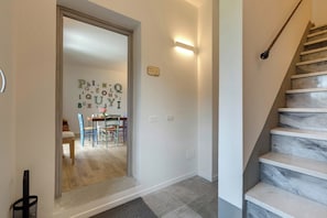 Eine Treppe mit Handlauf, eine Wand mit alphabetischen Buchstaben und ein Essbereich mit Stühlen und einem Tisch.