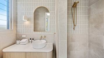 Un bagno moderno con un mobile lavabo, uno specchio e una doccia.
