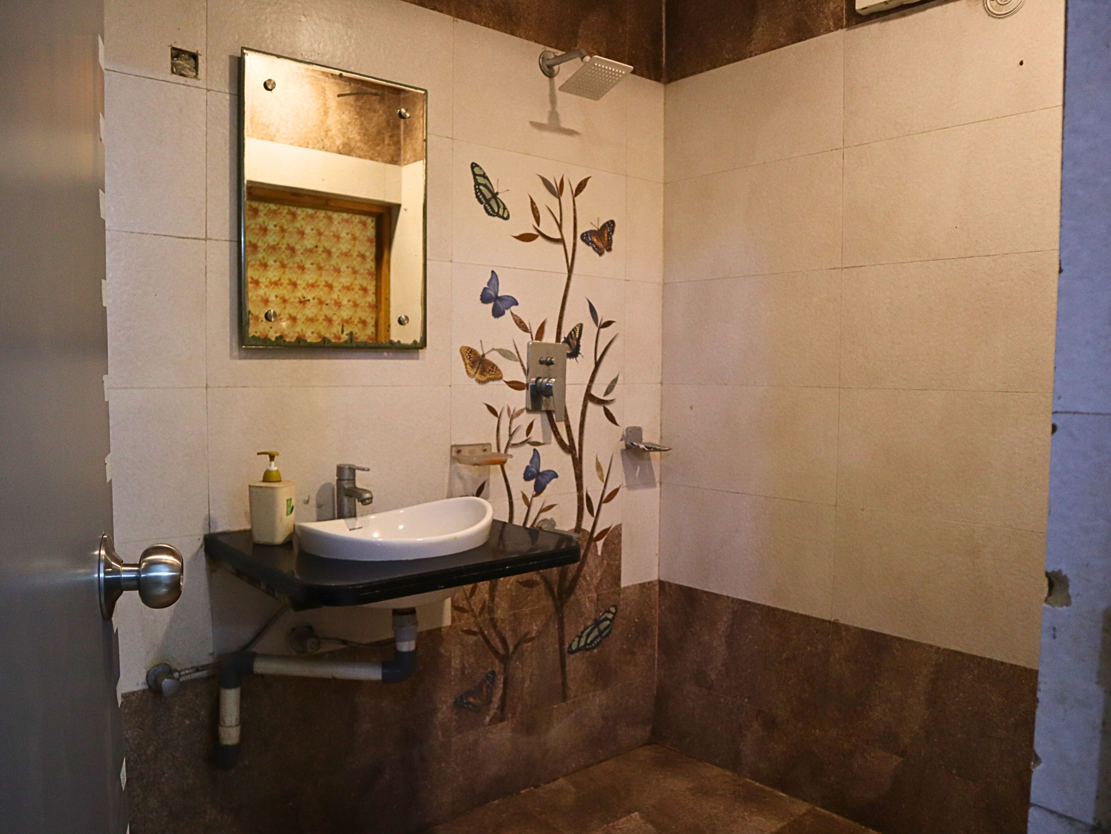 Un baño con lavamanos, espejo y ducha.