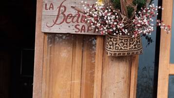 A chalkboard menu outside a wooden door with a sign above it that reads 'La Beaute Menu.'