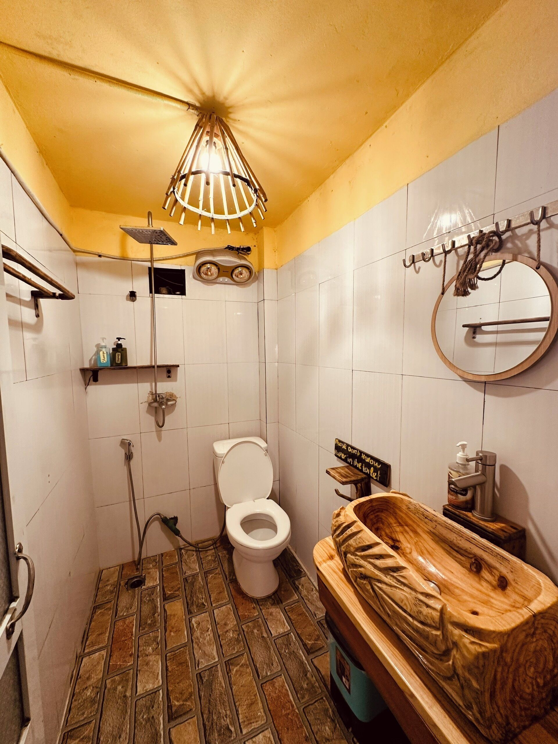A bathroom with a toilet, shower, and a wooden vanity.